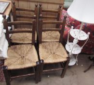 A set of four dining chairs with bar backs and rush seats together with a cast iron three tier