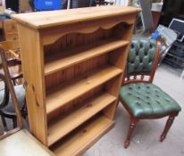 A modern pine bookcase together with an upholstered chair