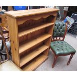 A modern pine bookcase together with an upholstered chair