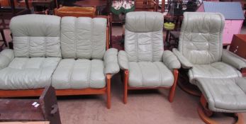 An Ekornes green leather two seater settee with matching armchair together with a green leather