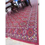 A large red ground rug with multiple geometric guls