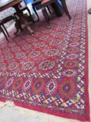 A large red ground rug with multiple geometric guls