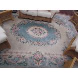 A large Chinese rug with a cream ground and central green medallion and flowers