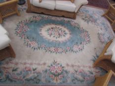 A large Chinese rug with a cream ground and central green medallion and flowers