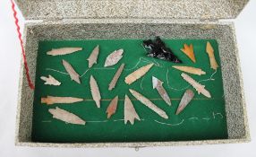 A collection of hard stone arrowheads, some barbed,