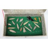 A collection of hard stone arrowheads, some barbed,