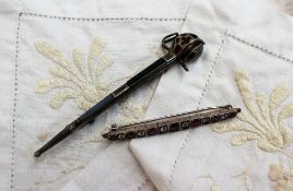 A ruby and white sapphire bar brooch set with seven oval faceted rubies and six round old brilliant