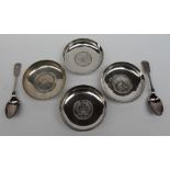A set of four white metal dishes each set with Marie Theresia Thalers, marked Pak 94 Sil,