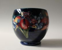 A Moorcroft pottery vase, decorated in the orchid pattern to a royal blue ground,
