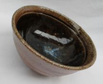 Phil Rogers - a studio pottery pedestal bowl with a blue splash and brown glaze, impressed mark,