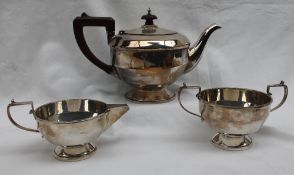 A George V silver three piece teaset, comprising a teapot, cream jug and twin handled sugar basin,