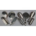 A George V silver backed part dressing table set, comprising a hand mirror,