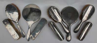 A George V silver backed part dressing table set, comprising a hand mirror,