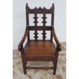 A 19th century oak elbow chair, the back rail carved with initials "I.M.