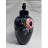 A Moorcroft pottery lamp base decorated in the anemone pattern to a royal blue ground,