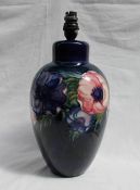 A Moorcroft pottery lamp base decorated in the anemone pattern to a royal blue ground,