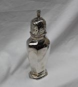 A George V silver sugar caster with a domed pierced top and a panelled body and spreading foot,