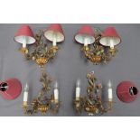 A set of four gilt metal two branch wall lights,