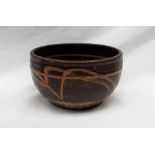 A studio pottery bowl decorated in browns, to a terracotta base,