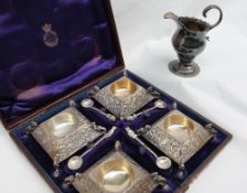 A set of four silver table salts of square form, embossed with leaves on claw feet,