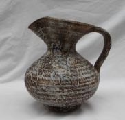 Waistel Cooper - a studio pottery jug, with a textured body in browns and cream,