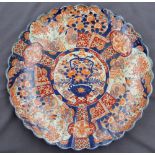 A large Japanese Imari charger, centrally decorated with a vase of flowers,