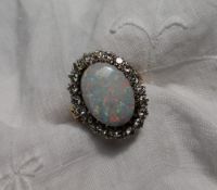 An opal and diamond ring the central oval opal approximately 17mm x 12mm,