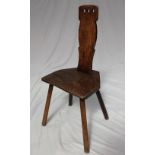 An 18th century elm spinning stool, the slat back with three ring finger holes to the top,