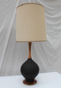 A 20th century turned walnut and textured ribbed black pottery table lamp, on a walnut base,