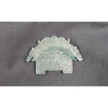 A Chinese green hardstone tablet possibly jade, of arched form, carved with a double headed dragons,