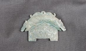 A Chinese green hardstone tablet possibly jade, of arched form, carved with a double headed dragons,