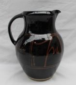A large studio pottery jug, with a dark brown glaze with light brown decoration,
