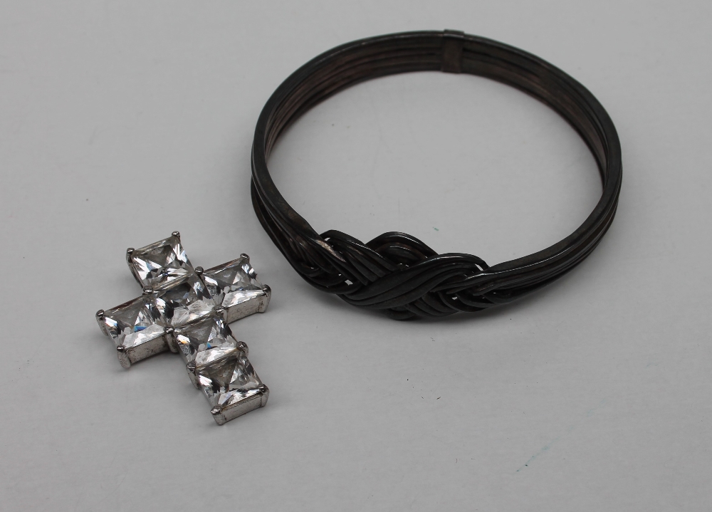 A silver paste set cross pendant together with a heavy white metal interlaced slave bracelet