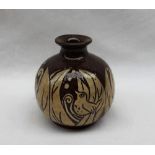 A studio pottery vase slip decorated with a bird amongst leaves in brown and cream,