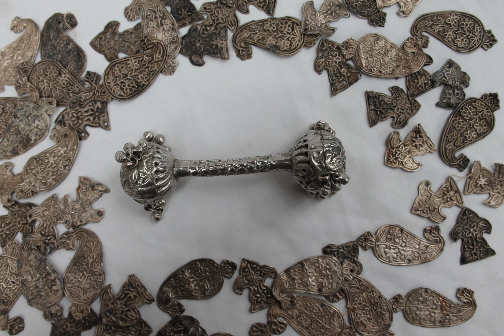 A white metal baby's rattle, with pierced ball ends and bells,