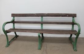 A Cast iron and slatted park bench, with three leg supports and wooden slats, cast "GW",