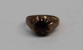A 9ct yellow gold Gentleman's signet ring, set with a circular faceted garnet,