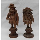 A pair of Black Forest carved figures with baskets upon their back, on circular carved bases, 13.