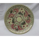 A Crown Ducal pottery charger decorated with pink and red flowers to a lime green ground,