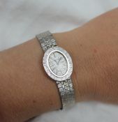 A Lady's 9ct white gold wristwatch, the oval dial with batons inscribed Bueche Girod,