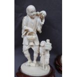 A 19th century ivory figure group of a man and children one of the children holding a cricket cage,