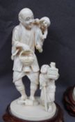 A 19th century ivory figure group of a man and children one of the children holding a cricket cage,