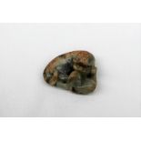 A Chinese jade carving of a lion dog recumbent playing with its puppy,