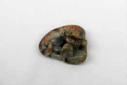 A Chinese jade carving of a lion dog recumbent playing with its puppy,