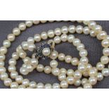 A two strand pearl necklace set with sixty regular shaped to one strand and forty eight to the