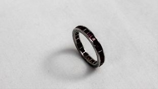 A ruby eternity ring set with princess cut rubies to a white metal setting and sides
