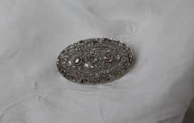 A diamond encrusted brooch of oval form,