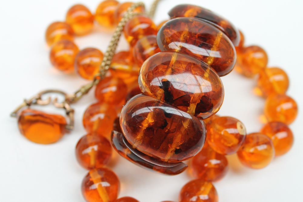 An amber bead necklace with spherical beads together with an expanding bracelet a rotating fob seal