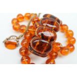 An amber bead necklace with spherical beads together with an expanding bracelet a rotating fob seal