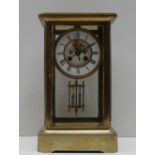 A Brass four glass mantle clock, with an enamel dial with Roman numerals and an insight movement,